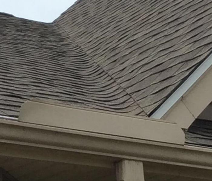 Roof with damaged gutter and soffit after storm