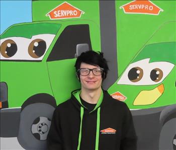 Employee at SERVPRO in front of a mural 