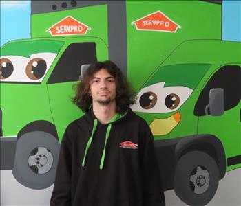 Employee at SERVPRO in front of a mural 