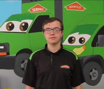 SERVPRO employee standing in front of green SERVPRO truck. 