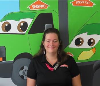 SERVPRO employee standing in front of green SERVPRO truck. 