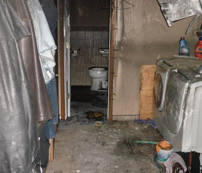 Laundry room and bathroom with heavy soot due to fire damage. 