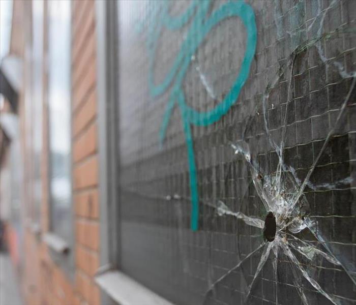 broken window with graffiti; we can help clean it up! like it never even happen.