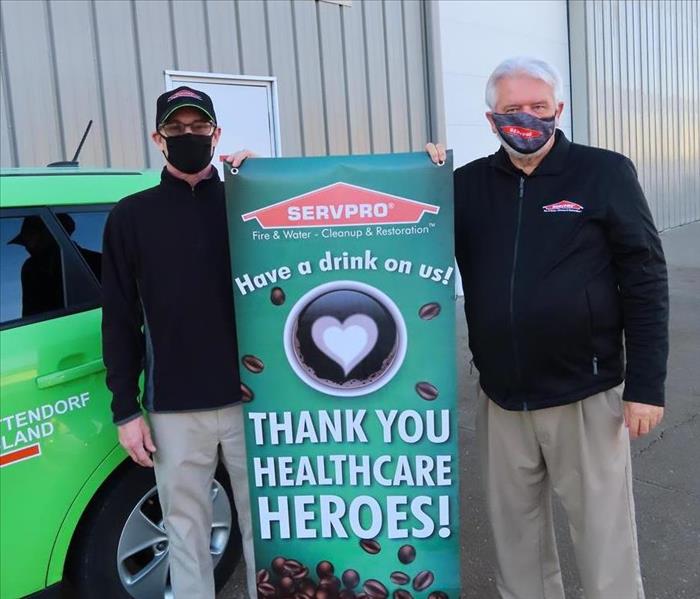 SERVPRO Employees in front of green vehicle with banner